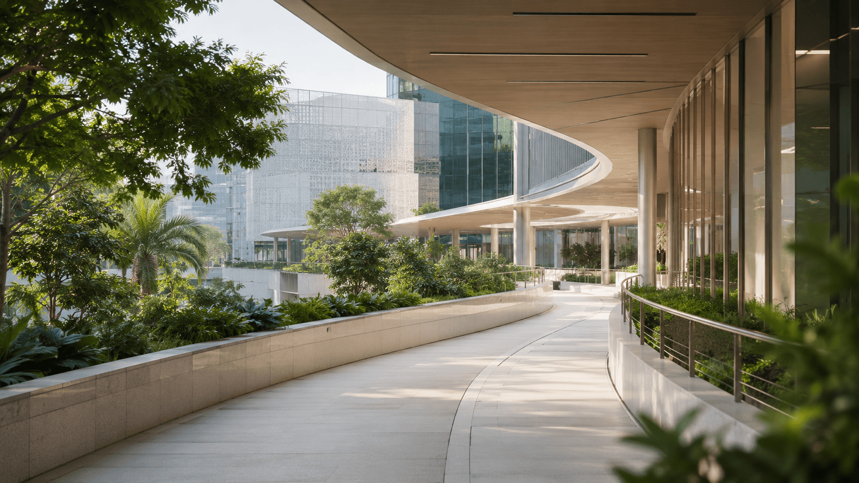 Curved modern outdoor walkway lined with lush greenery under a sleek wooden overhanging ceiling.
